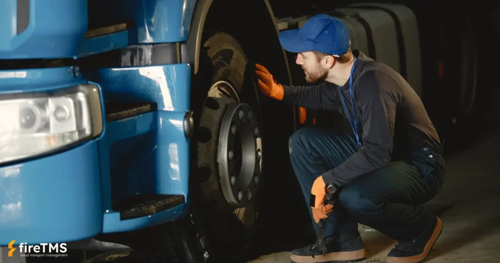 Mechanik zmienia koło w ciężarówce w warsztacie