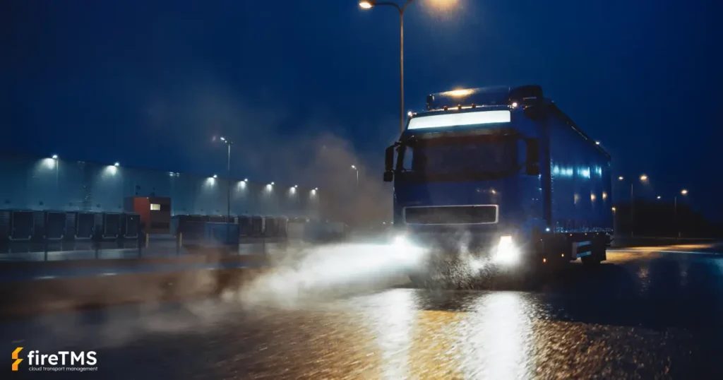 Ciężarówka jadąca nocą w deszczowych warunkach