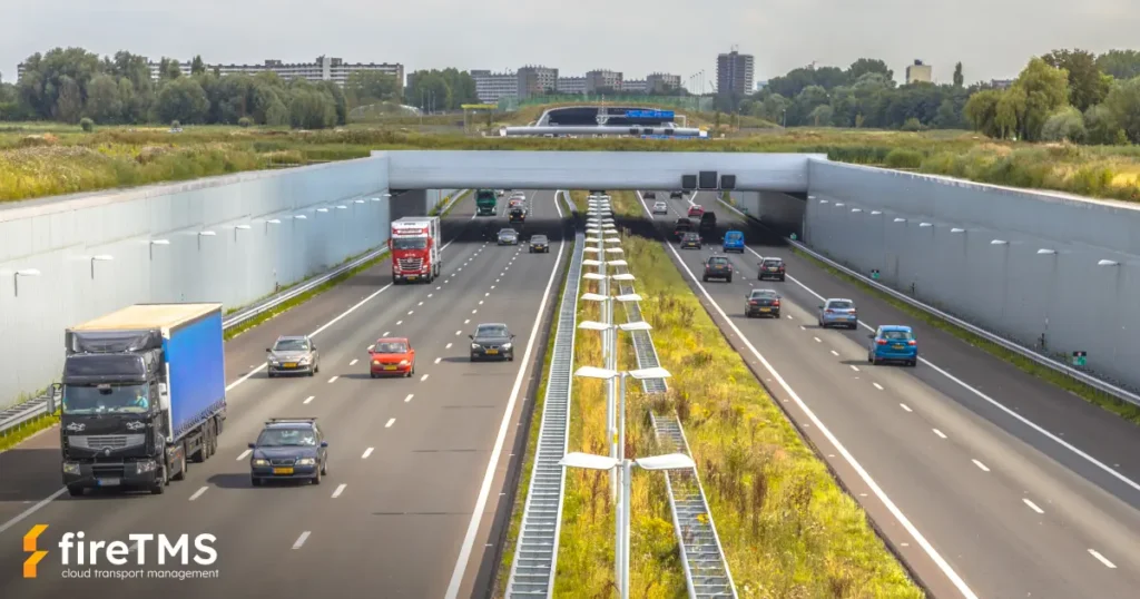 Samochody cieżarowe z wykupionymi eurowinietami jadą autostradą w konurbacji Randstad (Holandia)
