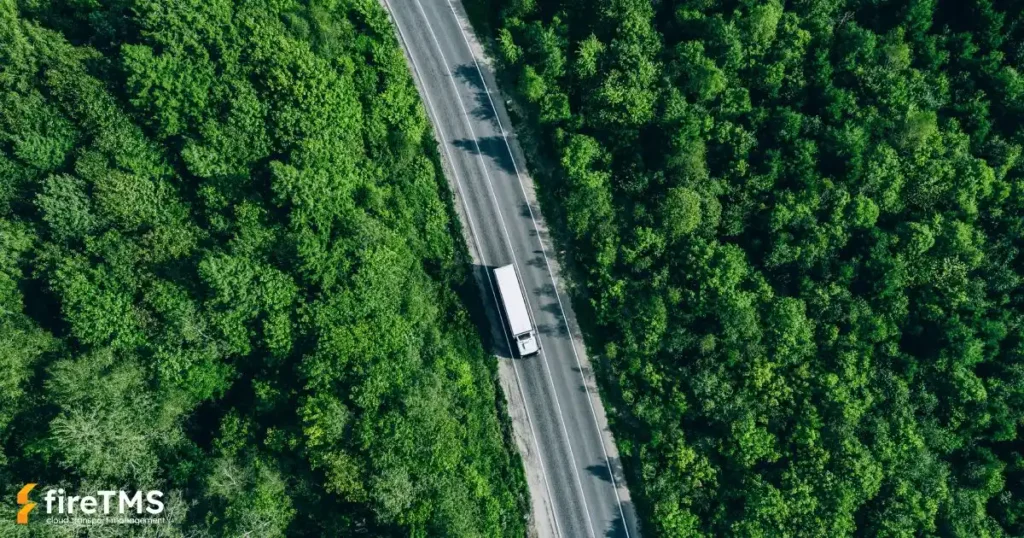 Ein von oben gesehener Lastwagen, der eine Straße durch einen grünen Wald befährt