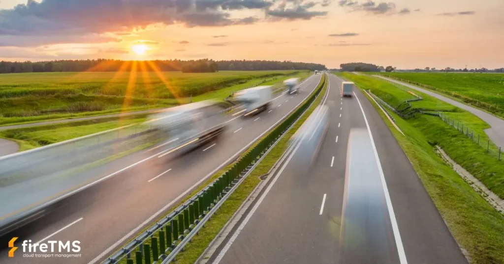 Lastwagen rasen über die Autobahn durch grüne Felder. Symbolische Darstellung des grünen Transports