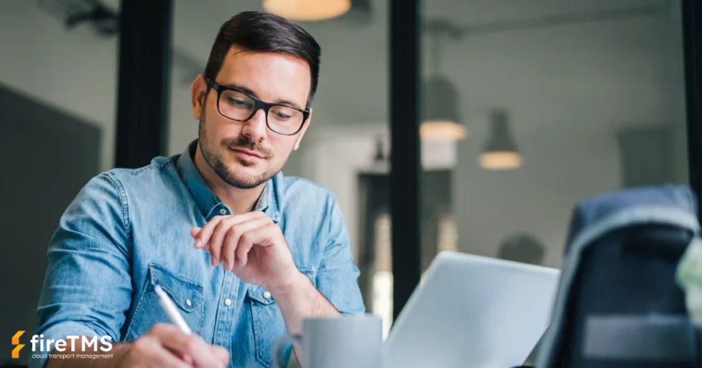 Spediteur, der im Büro mit dem fireTMS-System arbeitet.
