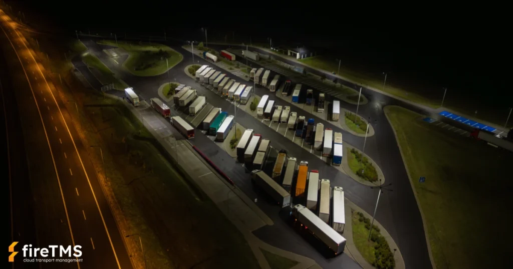 Samochody ciężarowe stoją na parkingu przy trasie szybkiego ruchu